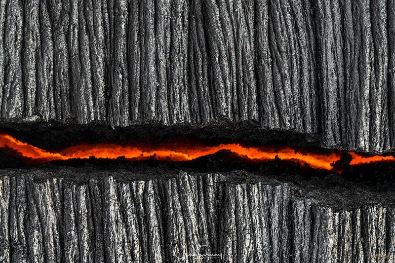 In this artistic image, a crack in the charred ground shows a river of hot lava running below. Shop this print & a variety of images of hot lava for sale.