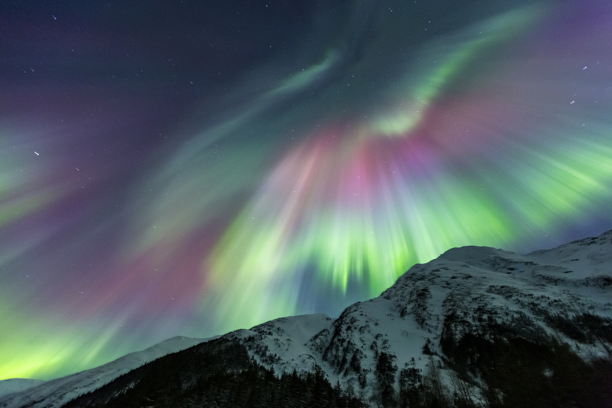 Northern Light colors of pink, red, yellow and green light up the sky above.