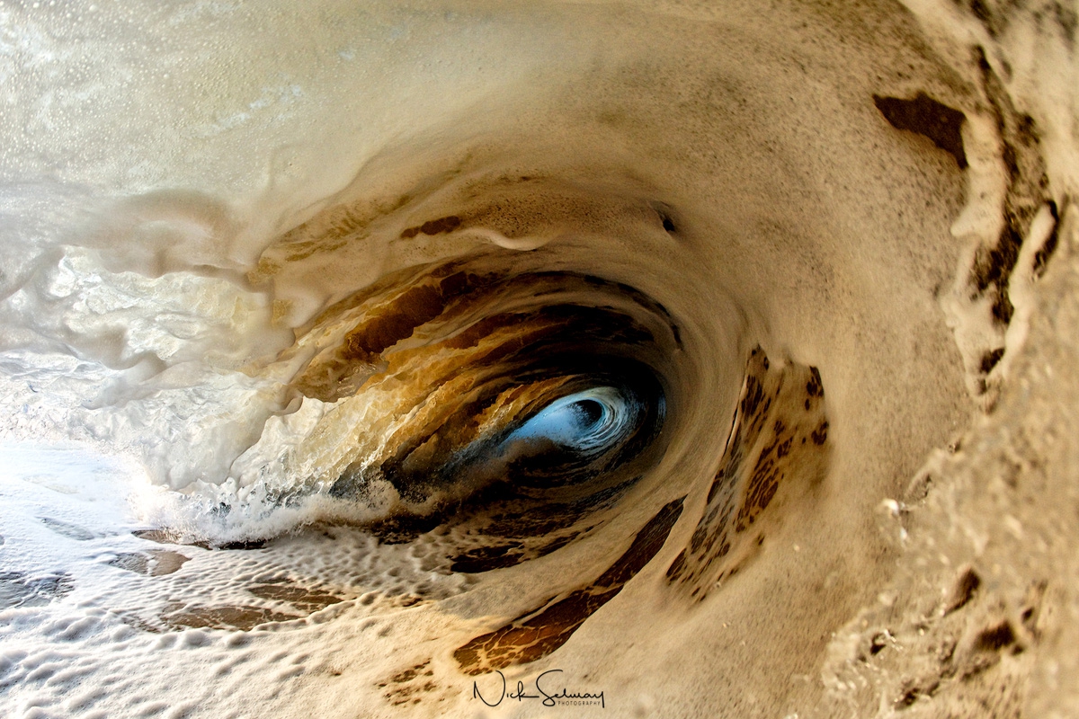 In this unique wave image, a turbulent wave full of sand and foam crashes into Hapuna Beach. Shop this print & a variety of ocean wave photography for sale.