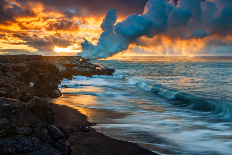 The billowing steam plume located on the end of lava bench along a new black sand beach  flows off into the Pacific Ocean as...