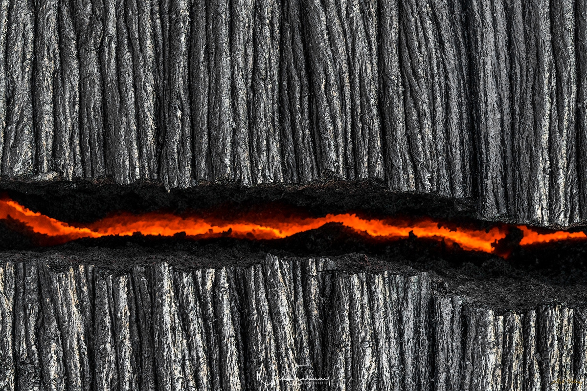 In this artistic image, a crack in the charred ground shows a river of hot lava running below. Shop this print & a variety of images of hot lava for sale.
