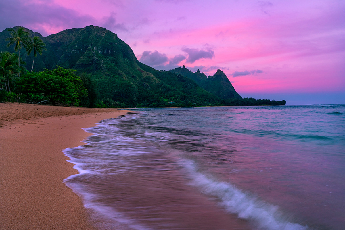 A clearing storm at sunrise gives way to a stunning pink sky.  Tunnels Beach (aka Makua Beach) located at Ha'ena Point on Kauai...